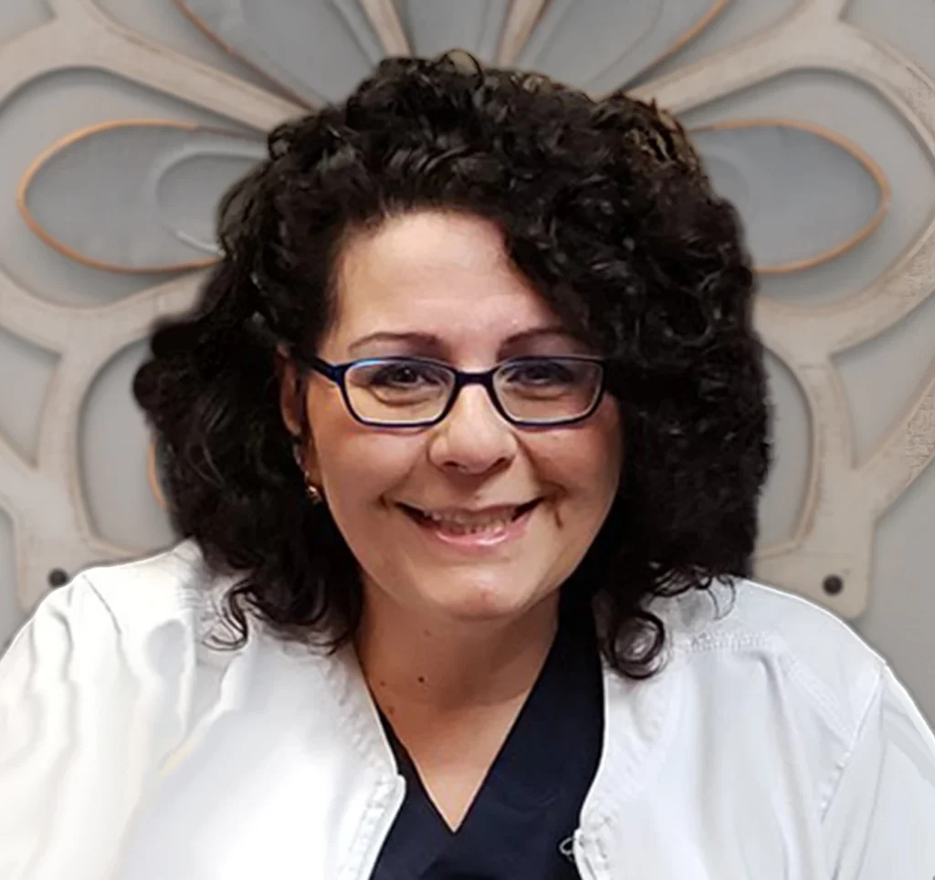 Dr. Carolyn Giannelli, DDS, smiling in a white dental coat